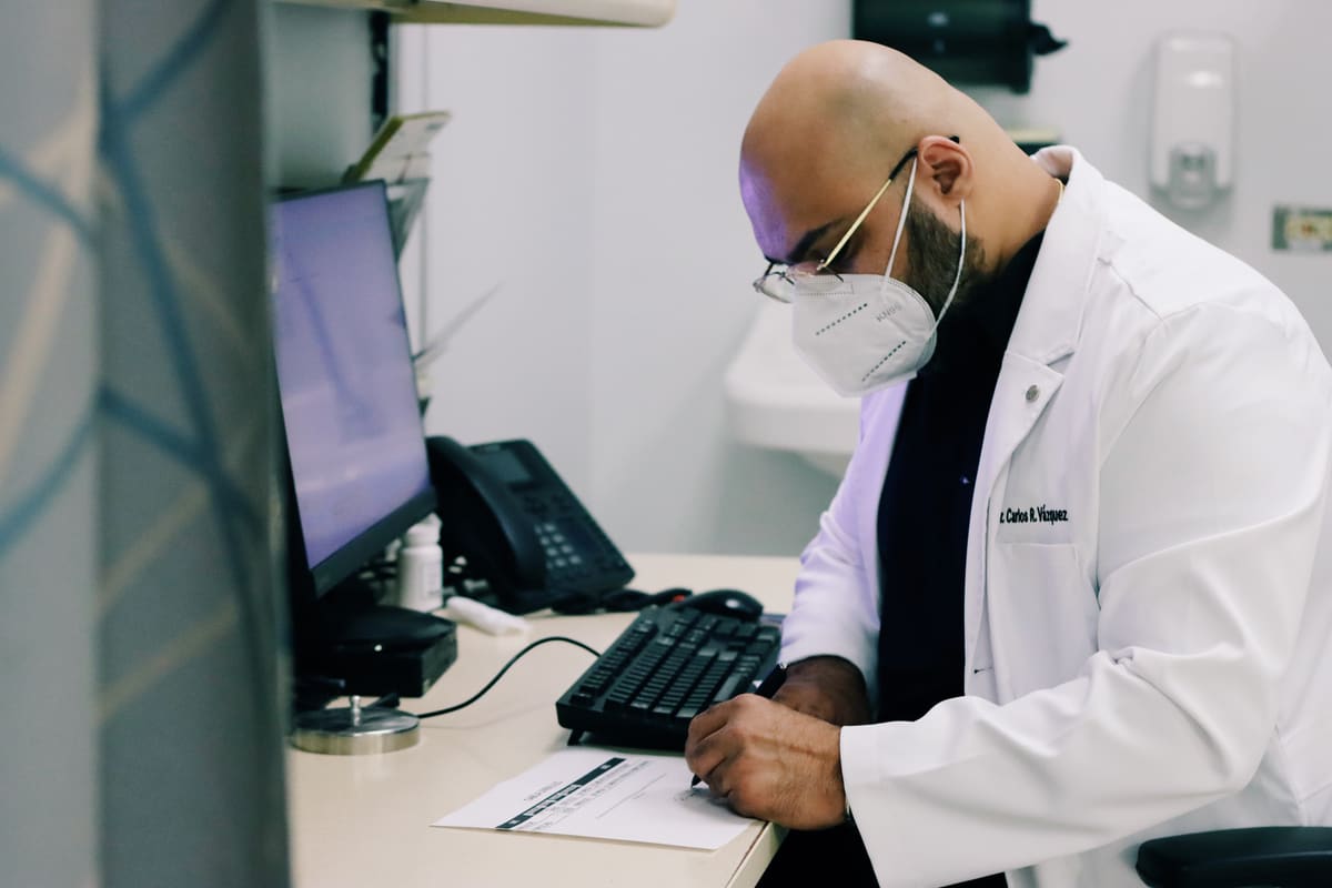 Médico de Varmed Health Center completando el expediente de un paciente